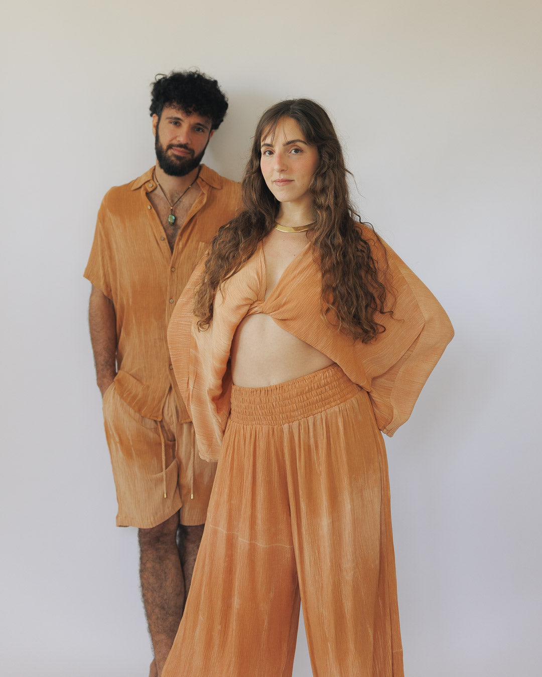 דוגמנית ודוגמן בסטים מויסקוז קרפ בגוון כתום חמום