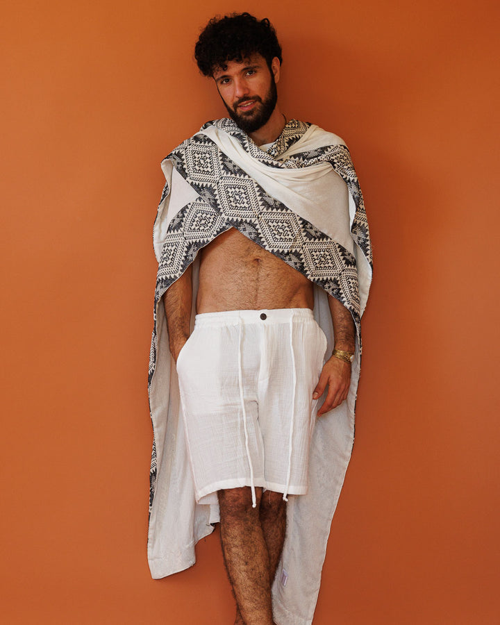 פונצו צעיף לבן, עם עיטור גיאומטרי שחור לבן מנצנץ בשוליים לגבר