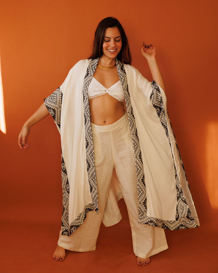 פונצו צעיף לבן, עם עיטור גיאומטרי שחור לבן מנצנץ בשוליים לאישה